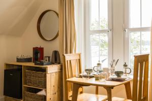 uma sala de jantar com uma mesa e um espelho em The Old School House B&B em Gairloch