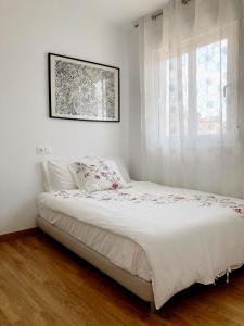 1 dormitorio con 1 cama blanca y ventana en Calle Malta 19 Villa, en Santa Pola
