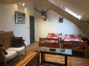a living room with two beds and a deer head on the wall at B&B Le Moulin de Fernelmont in Forville