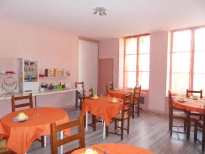 a dining room with tables and chairs and windows at Chambres d'hôtes d'Accolay in Accolay