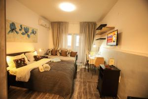 a hotel room with two beds and a desk at Elena Apartments in Tel Aviv