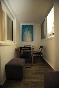 a room with two chairs and a table and a painting at Elena Apartments in Tel Aviv