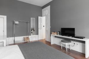 a room with a television, a refrigerator, and a sink at GuestReady - INNVICT in Porto