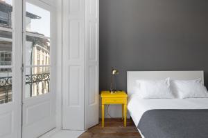 a white bed sitting next to a window in a room at GuestReady - INNVICT in Porto