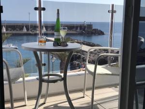 een tafel met wijnflessen en glazen op een balkon bij Mar de las Calmas in La Restinga