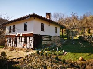 an old house with a garden in front of it at Къща за гости Ножери in Tryavna