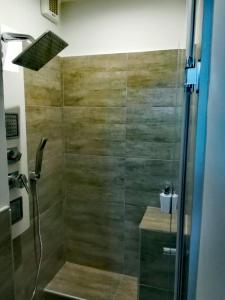 La salle de bains est pourvue d'une douche avec une porte en verre. dans l'établissement Dimora del sole, à Catane