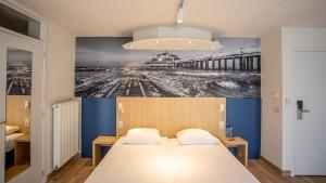 a bedroom with a bed with a picture of a pier at Hotel Paradisio by WP Hotels in Blankenberge