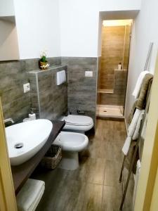 een badkamer met een wastafel, een toilet en een douche bij Dimora del sole in Catania