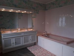 a bathroom with two sinks and a tub and a large mirror at Chambre du Nouvion in Le Nouvion-en-Thiérache
