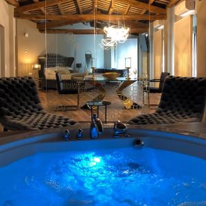 a hot tub in a room with chairs and a living room at Les Clarisses Boutique Hotel in Vic