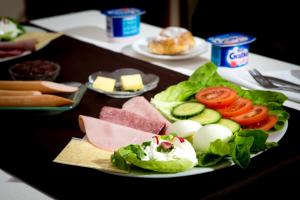 a plate of food with eggs and vegetables on a table at Hotelik - Modlin Airport in Nowy Dwór Mazowiecki