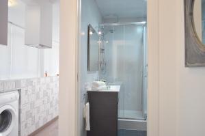 een badkamer met een douche, een wastafel en een wasmachine bij CIUDADELA PARK 1 in Barcelona