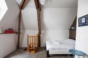a bedroom with a white bed and a chair at Le Petit Mont by Cocoonr in Rennes