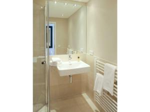 uma casa de banho com um lavatório e um espelho em Victoriaresidenz-App-12-Ekki-s-Suite em Westerland