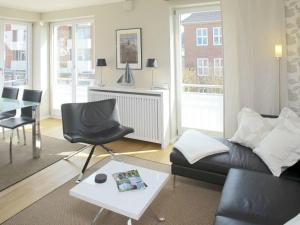 uma sala de estar com um sofá e uma mesa em Victoriaresidenz-App-12-Ekki-s-Suite em Westerland
