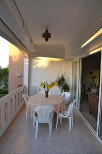 einen Tisch und Stühle auf einem Balkon mit einem Tisch in der Unterkunft Villa Standing bord de mer Club Evasion Tiznit in Mirleft