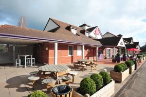 a patio with tables and chairs and a building at Weathervane Hotel by Greene King Inns in Stoke on Trent