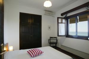 a bedroom with a bed with a red pillow on it at Lagonisi Beach Resort in Ormos Panagias