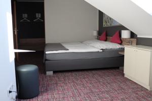 a small bedroom with a bed and a staircase at Ilvericher Hof in Meerbusch