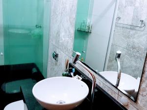 a bathroom with a sink and a mirror at Quarto com Varanda - Recanto do Sabiá in Campinas
