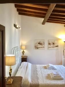 1 dormitorio con 1 cama blanca y 2 cuadros en la pared en DaLu Florence apartment Lucilla - private car park 15 minutes to the city center en Florencia