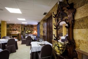 a dining room with tables and chairs and a mirror at Hotel Rio Piedra in Nuévalos