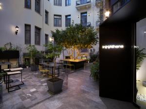 a courtyard with tables and potted plants in a building at InnAthens in Athens