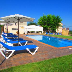 a swimming pool with lounge chairs and an umbrella at Hostal Can Bassalis in Pals