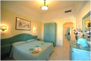 a hotel room with a bed and a television at Residence Cala Liberotto in Cala Liberotto