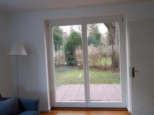 a sliding glass door with a view of a yard at Beautiful House in Zehlendorf in Berlin