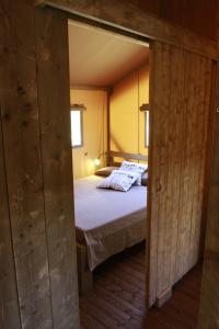 - une petite chambre avec un lit dans l'établissement Glamping Alcantara, à Motta Camastra