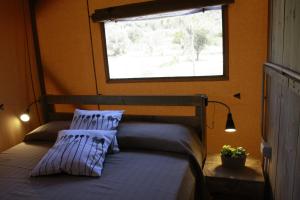 Glamping Alcantara في Motta Camastra: غرفة نوم بسريرين ونافذة