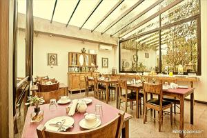 a restaurant with tables and chairs and a large window at Posada Boutique Las Terrazas in Colonia del Sacramento