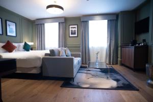 um quarto com uma cama, um sofá e uma mesa em Counting House em Londres