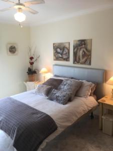 a bed in a bedroom with paintings on the wall at Quiet apartment overlooking the swimming pool in Armação de Pêra +57 photos