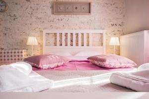 a bedroom with a large bed with pink pillows at Nafsika Luxury Suite in Corfu Town