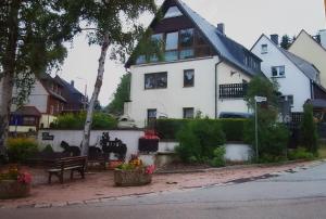 een wit huis met een bankje ervoor bij Ferienwohnungen Dagmar in Kurort Oberwiesenthal