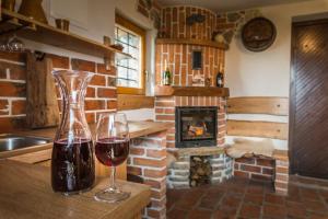 un bicchiere di vino seduto su un tavolo con camino di Vineyard Cottage Rataj 2 a Novo Mesto