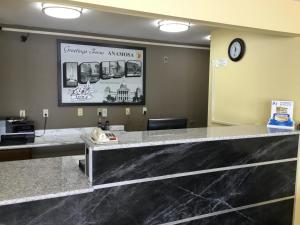 a reception desk in a waiting room with a clock at Super 8 by Wyndham Anamosa IA in Anamosa
