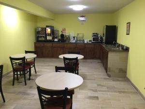 a restaurant with tables and chairs and a kitchen at Circle S Motel in Anamosa
