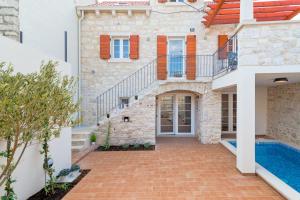 uma villa com uma piscina e uma casa em Holiday home Rocca em Supetar