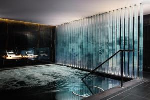 a bath room with a pool and a glass door at Corinthia London in London