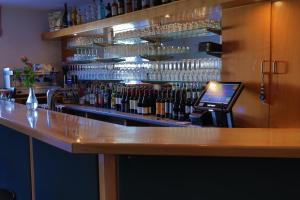 een bar met een bar met flessen wijn bij Ilvericher Hof in Meerbusch