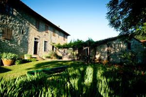 stary kamienny budynek z ławką w trawie w obiekcie Agriturismo Marchesi Gondi w mieście Pontassieve