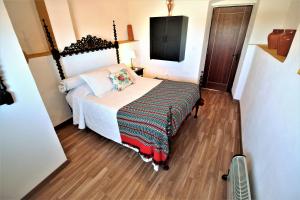 a small bedroom with a bed and a tv at Casa do Castelo in Elvas