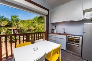 a kitchen with a balcony with a table and chairs at Le Village de la Pointe in Le Vauclin
