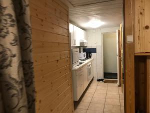 a kitchen with white appliances and a wooden wall at Nordhagen 17 in Stavanger