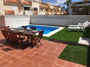 stół i krzesła na patio przy basenie w obiekcie CHALET 84 con PISCINA PRIVADA w mieście Callao Salvaje +5 zdjęć