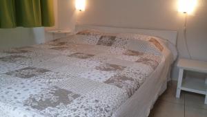 a bedroom with a bed with a white and brown quilt at Tutini Dvori in Primošten